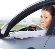 Business woman looking at camera through the car window.