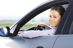 Business woman looking at camera through the car window.