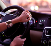 Driving a car at night - pretty, young woman driving her modern