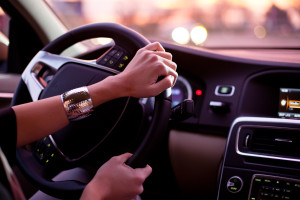 Driving a car at night - pretty, young woman driving her modern